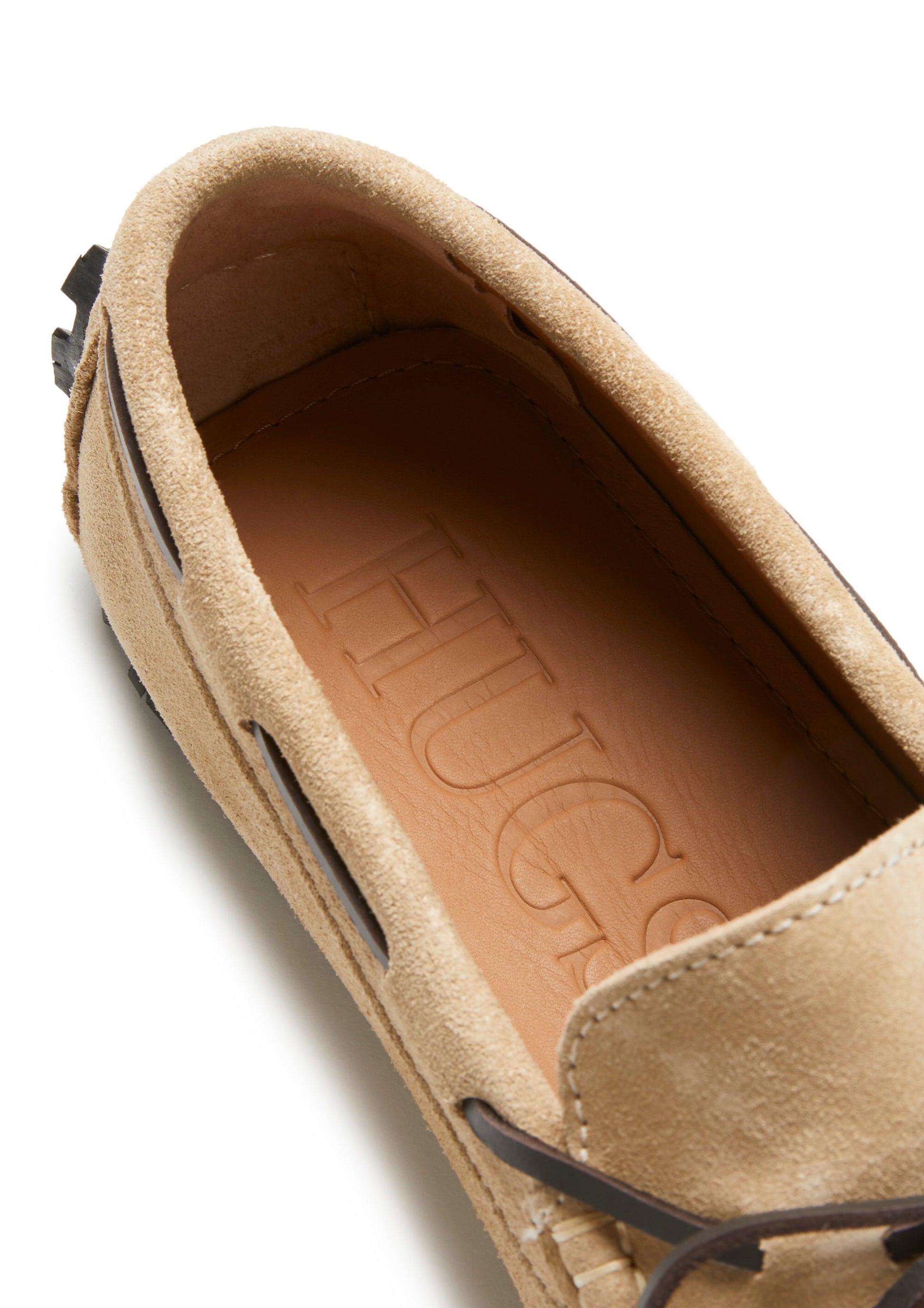 Tan suede loafer with 'Hugs' branding on the insole against a white background