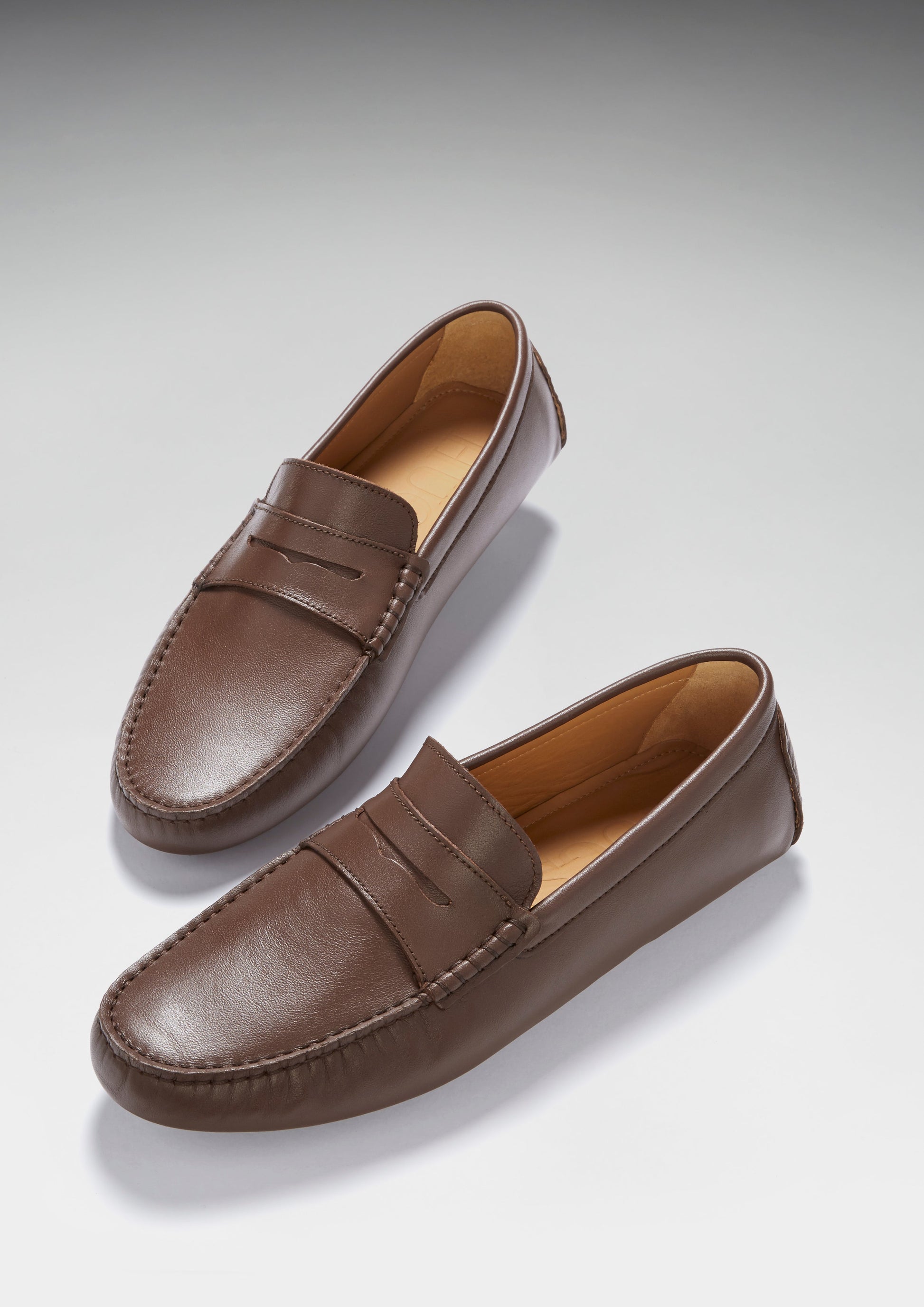 Pair of brown loafers on a light gray background