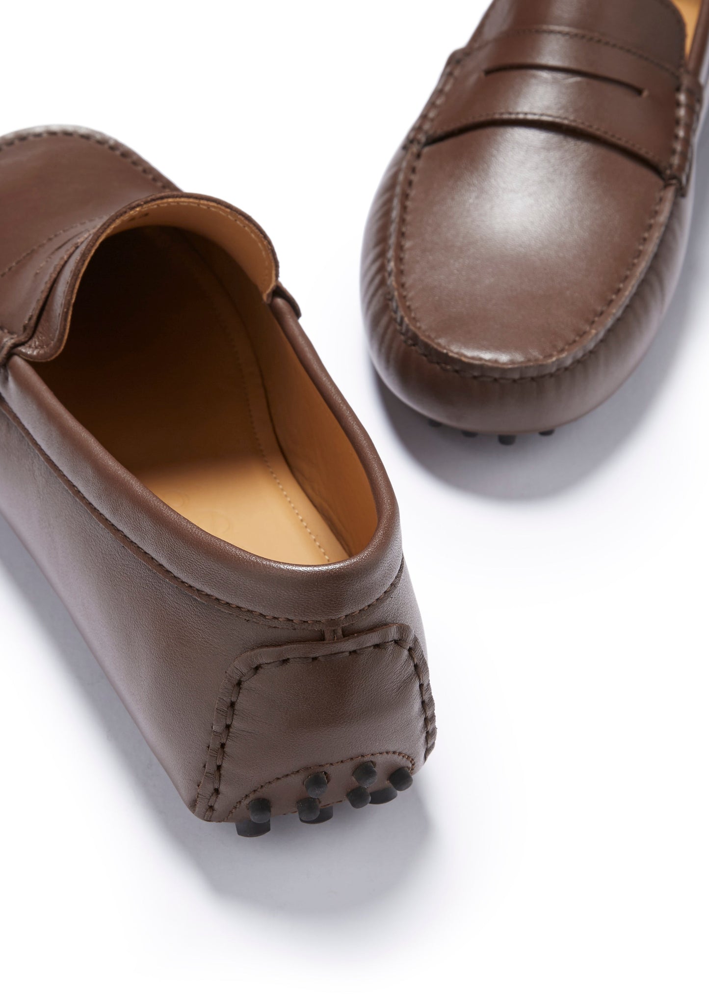 Brown leather loafers on a white background
