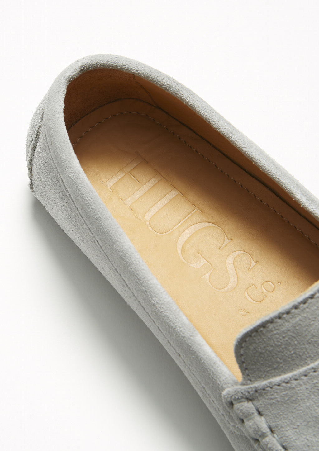 Gray suede loafer with visible brand logo on a white background