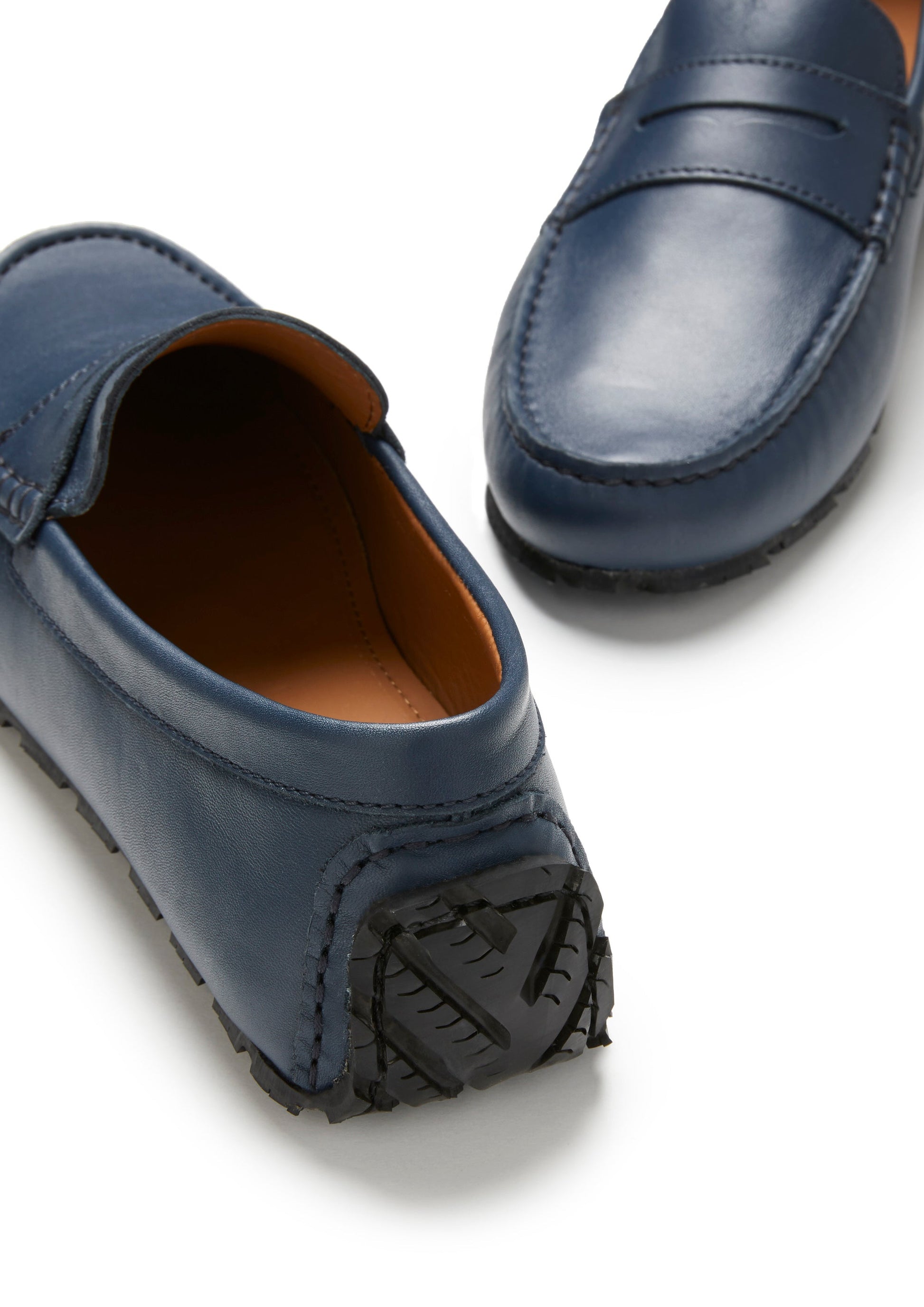 Blue loafers with brown soles on a white background