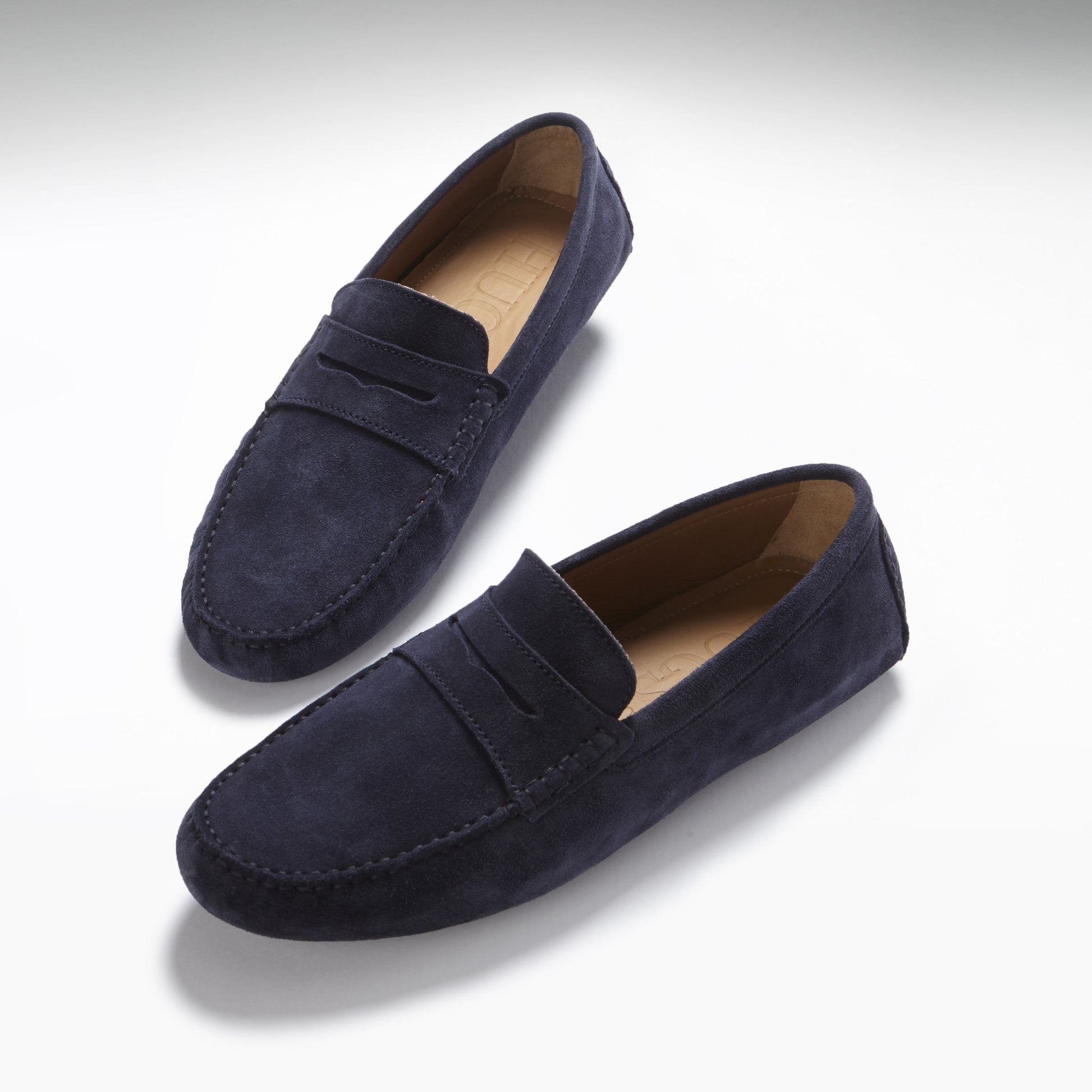 Pair of navy blue loafers on a light gray background