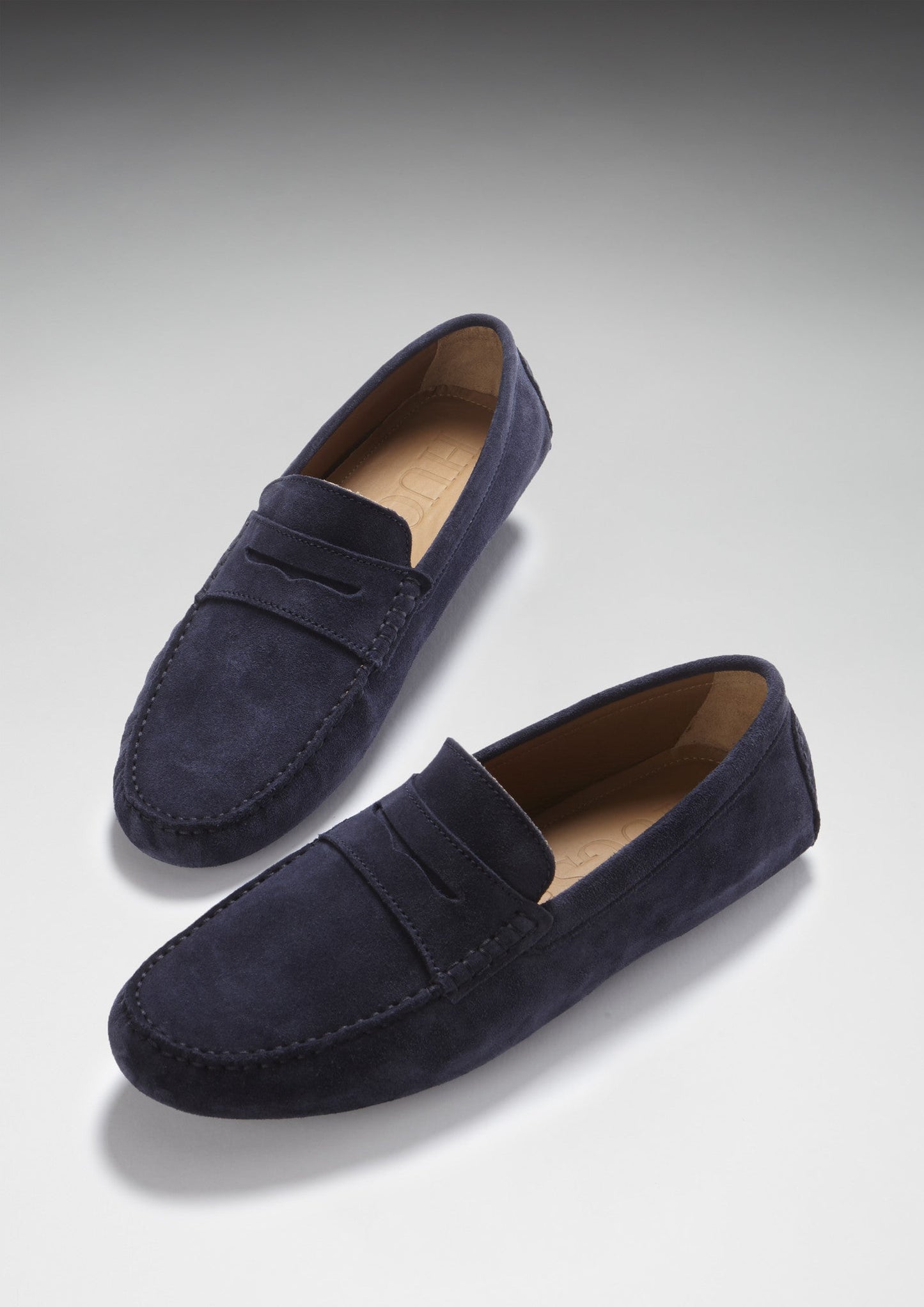 Pair of navy blue loafers on a light gray background