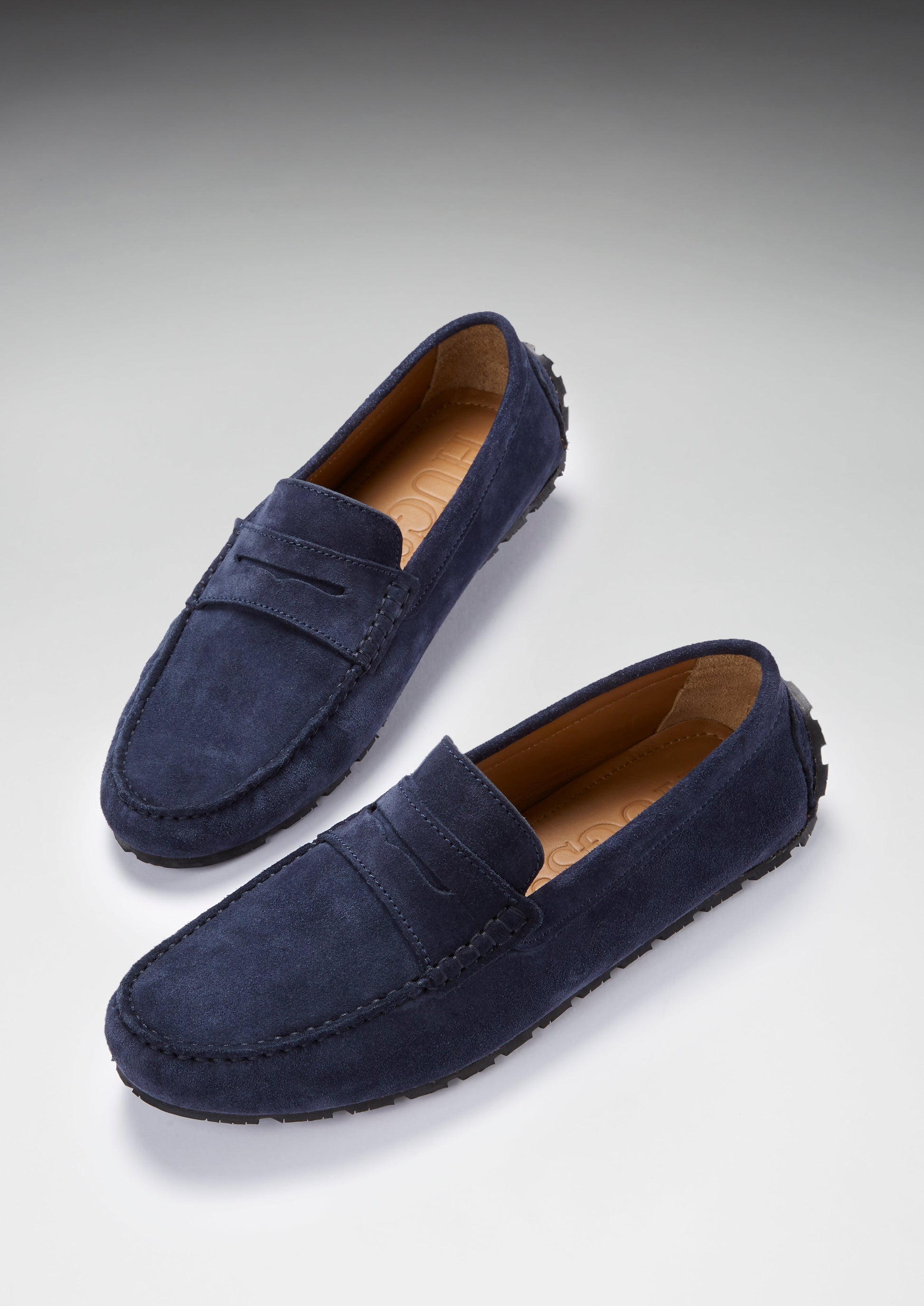 Pair of navy blue loafers on a light gray background