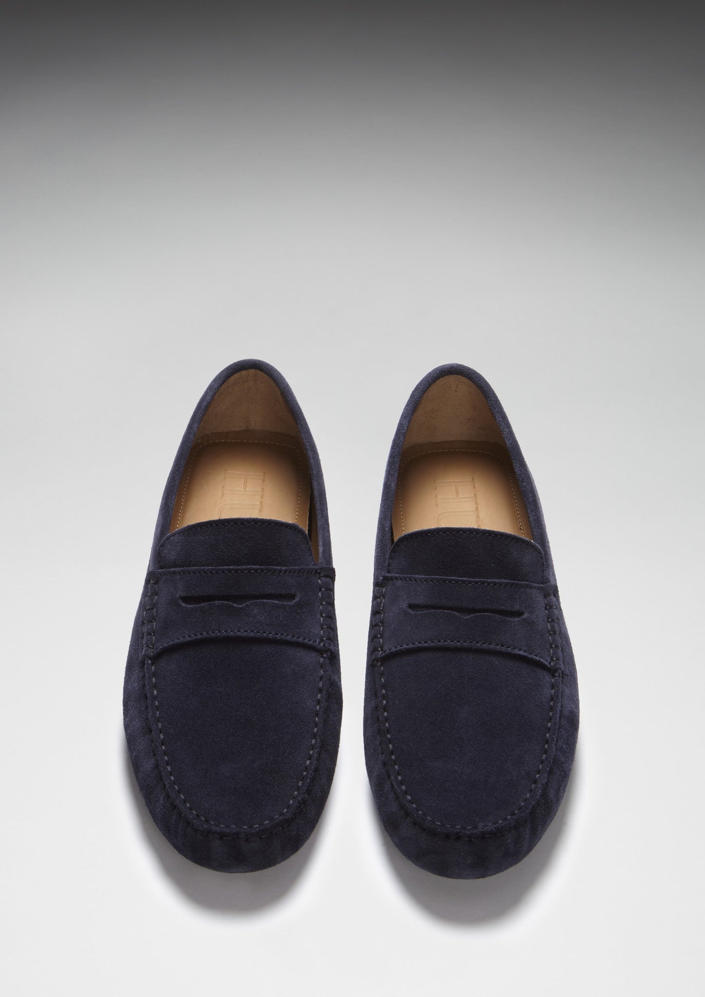 Pair of navy blue loafers on a light gray background