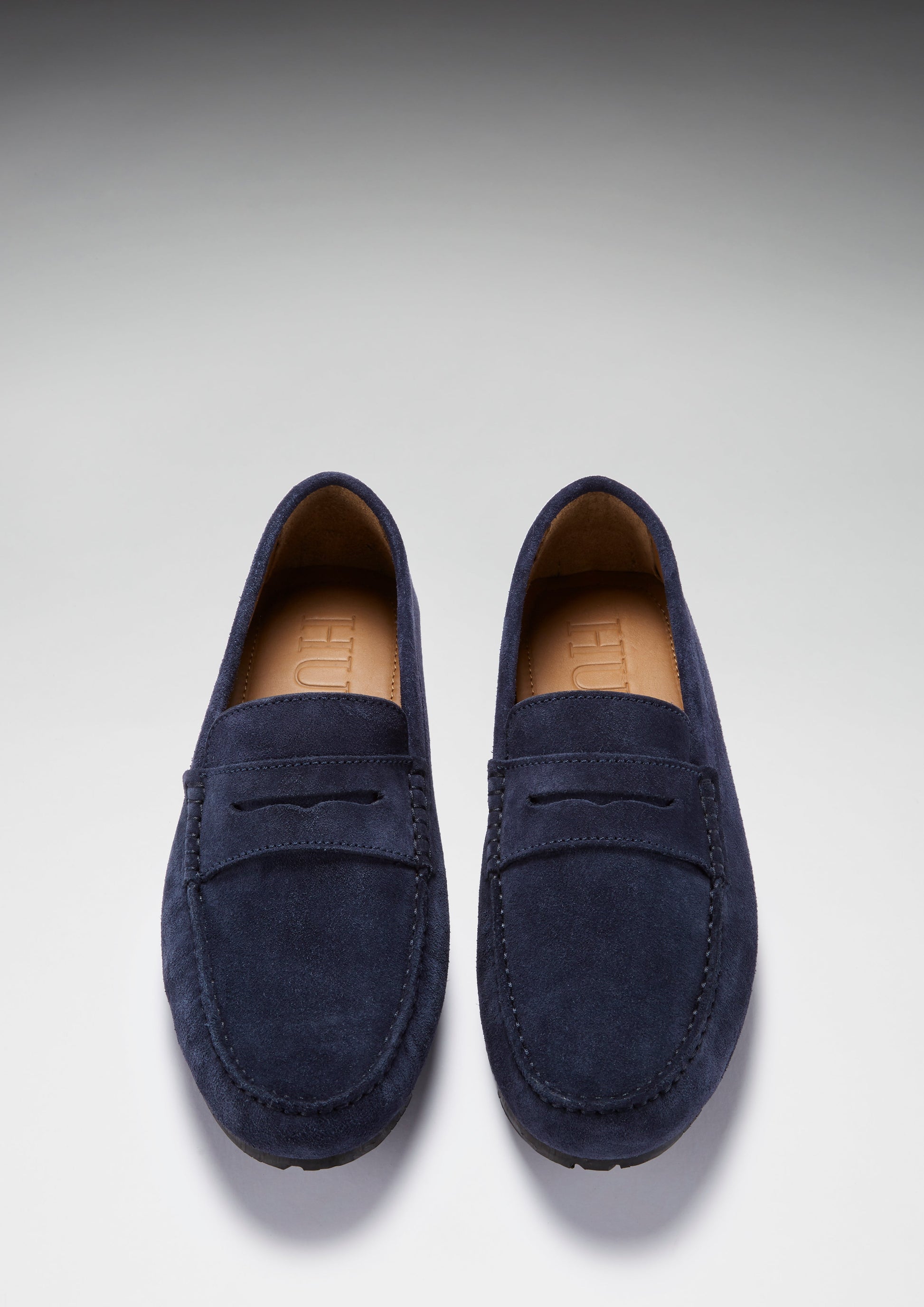 Pair of navy blue loafers on a light gray background