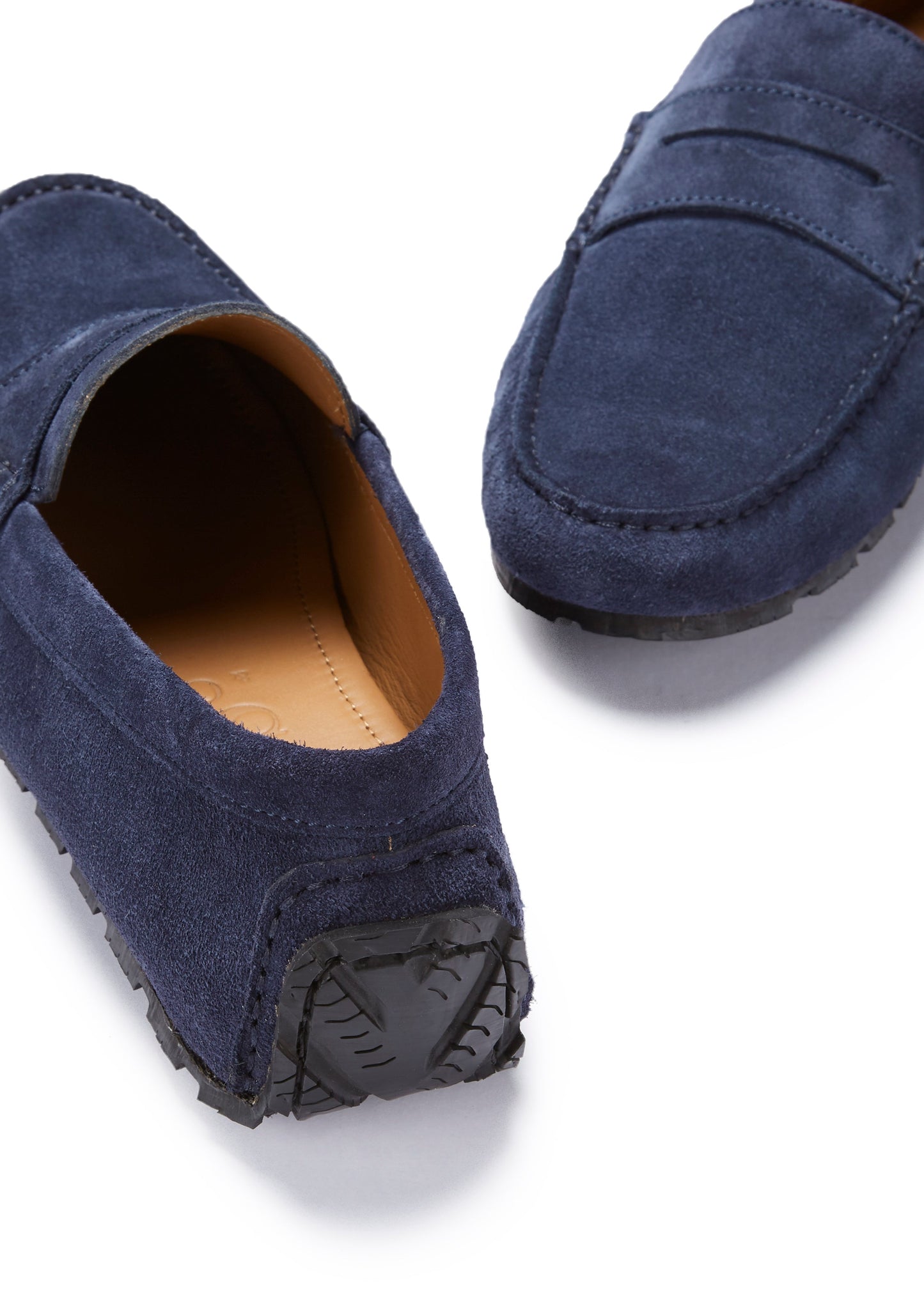 Navy blue loafers with brown soles on a white background