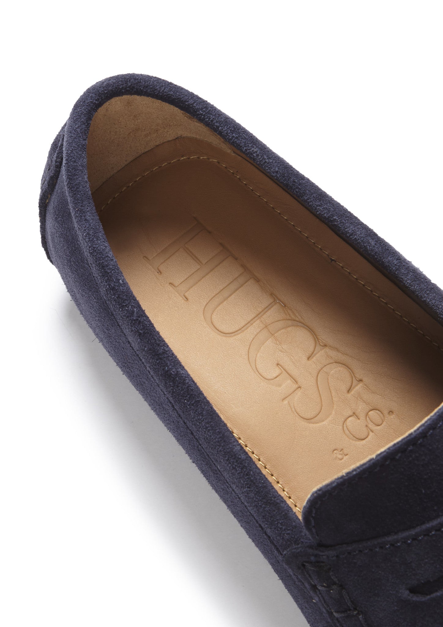 Navy blue suede loafer with 'HUGS' branding on the insole against a white background