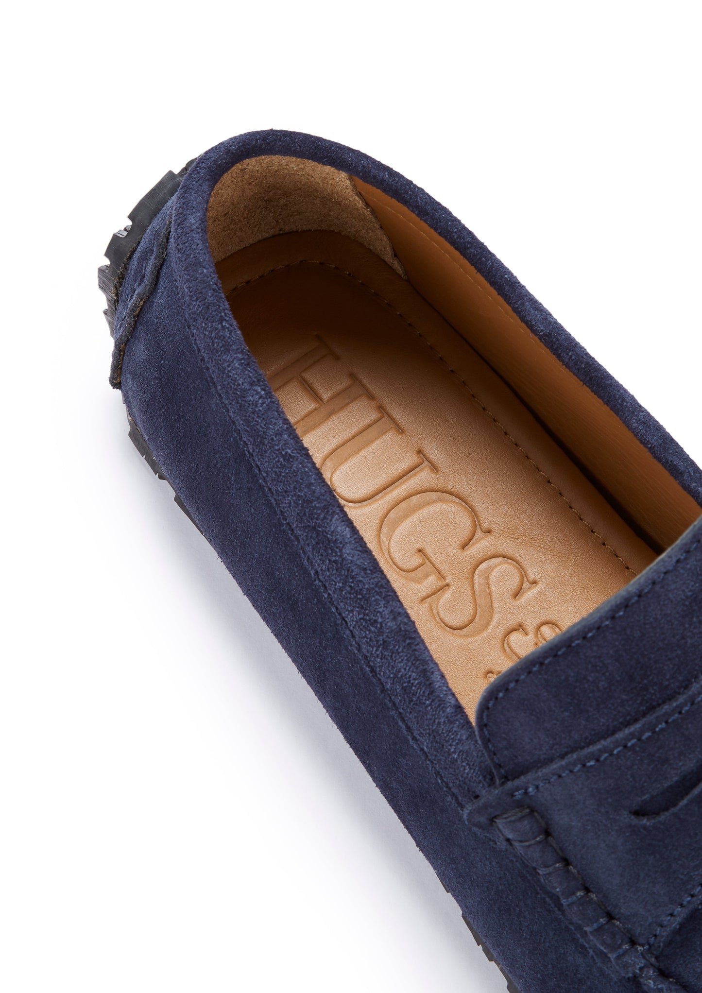 Navy blue suede loafer with a tan insole displaying 'HUGS' branding on a white background.