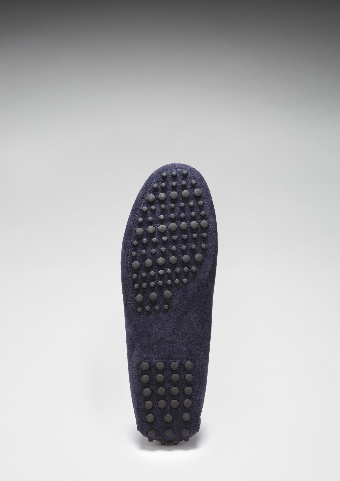 Navy blue shoe sole with textured pattern on a light gray background