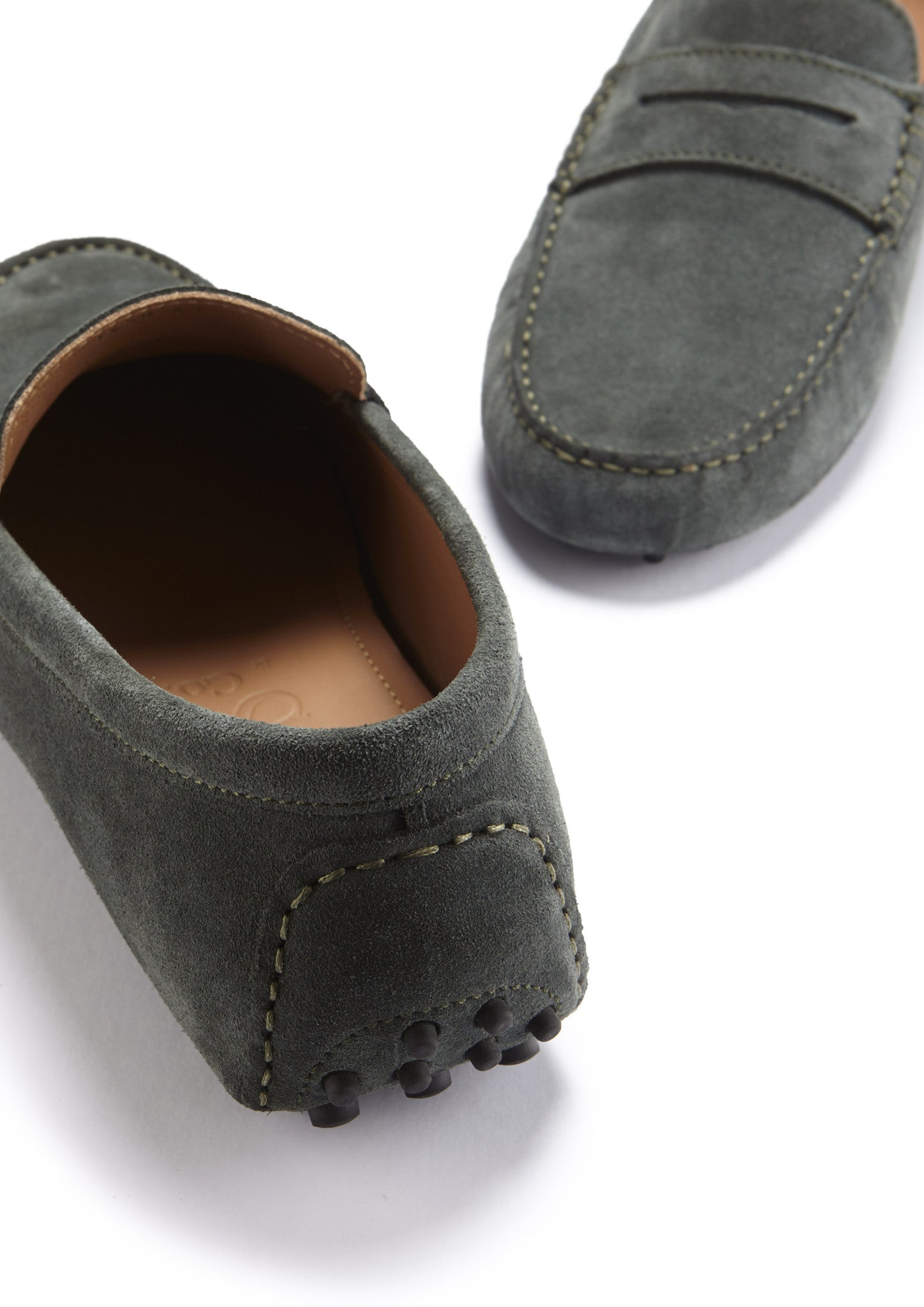 Gray suede loafers on a white background