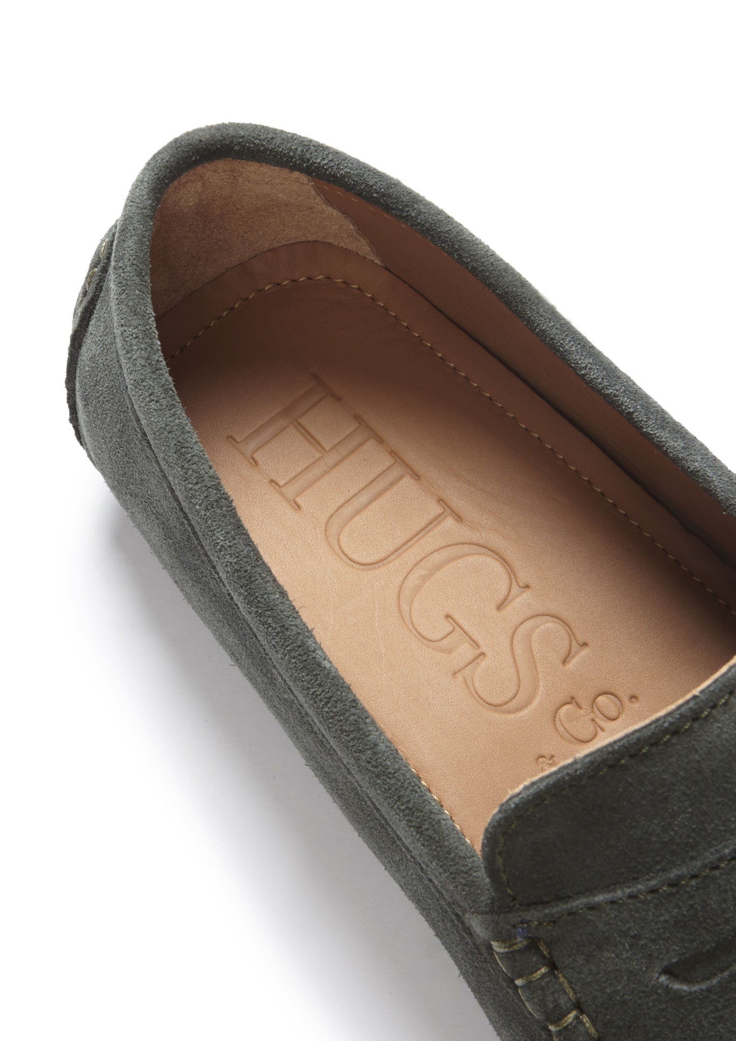 Green suede loafer with 'Hugs & Co.' branding on a white background