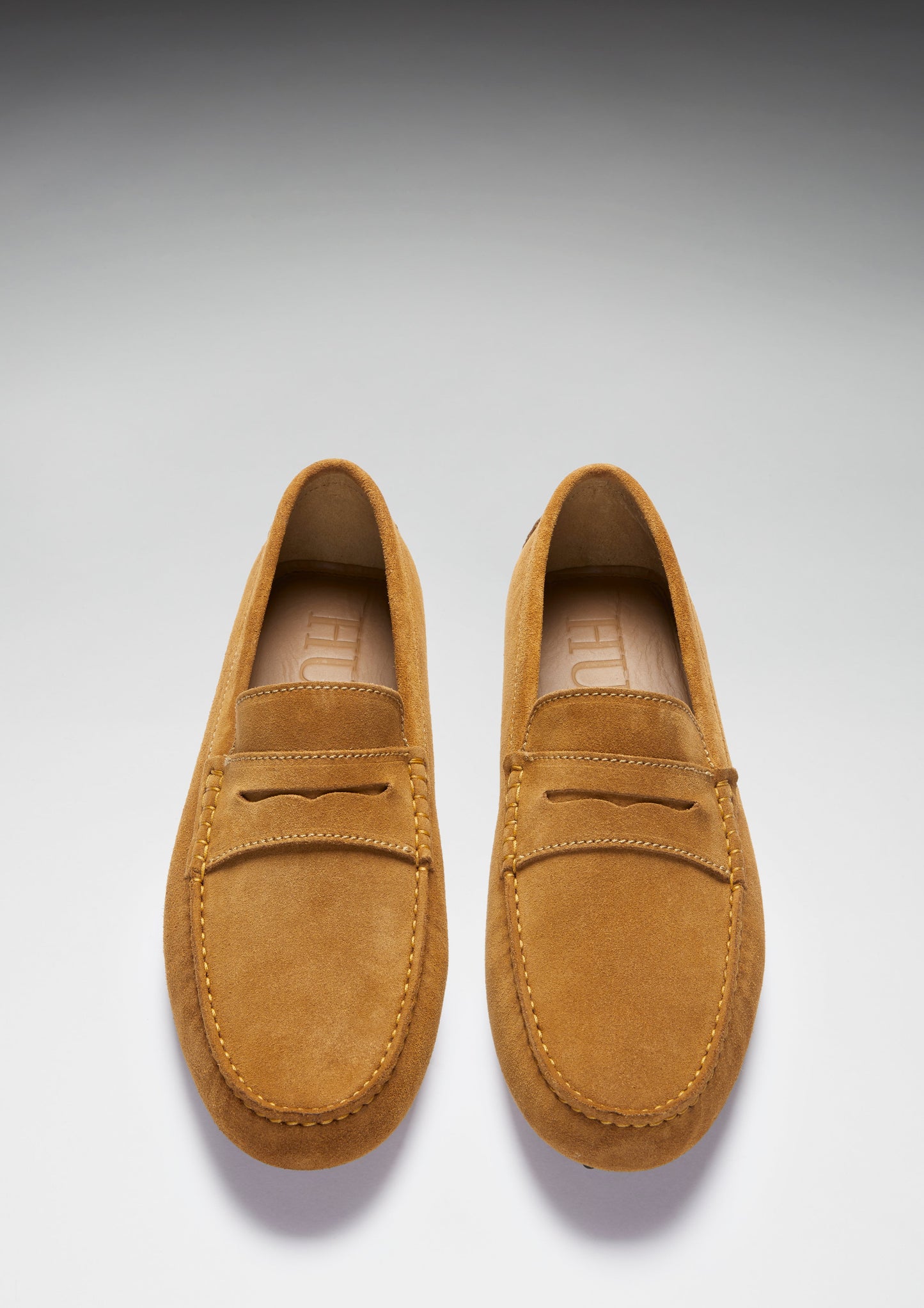 Pair of tan loafers on a light gray background