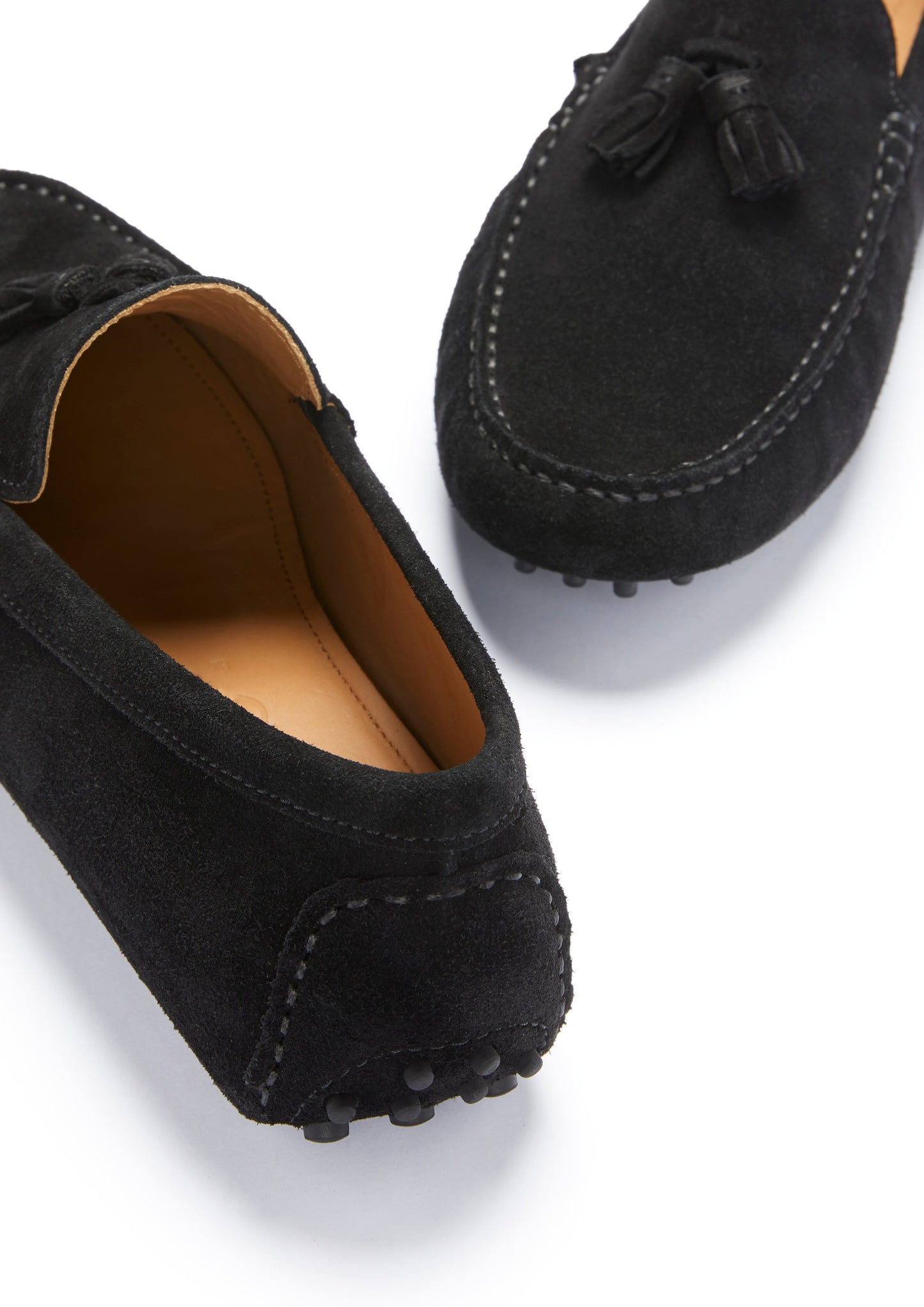 Black suede loafers with tassels on a white background