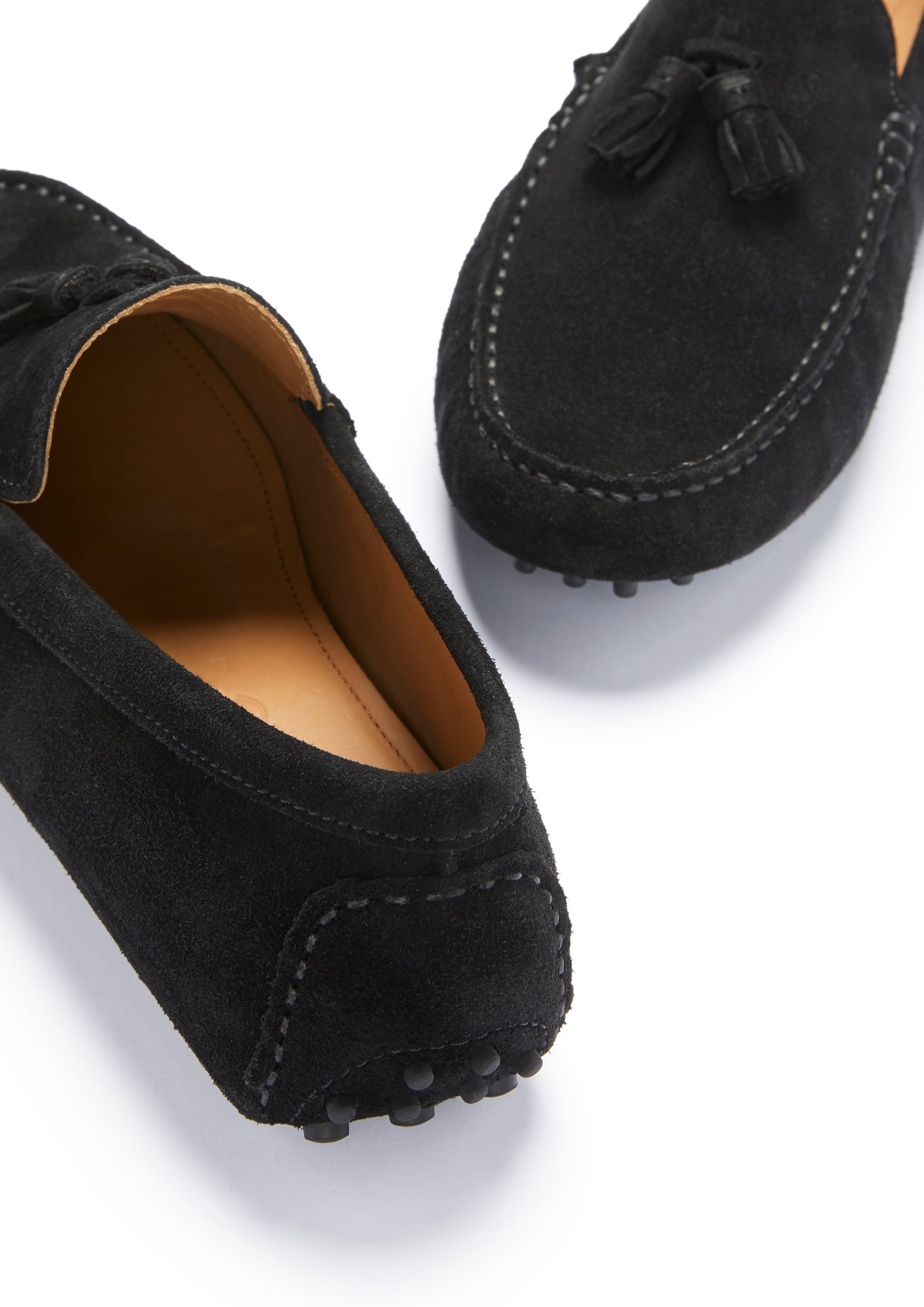 Black suede loafers with tassels on a white background