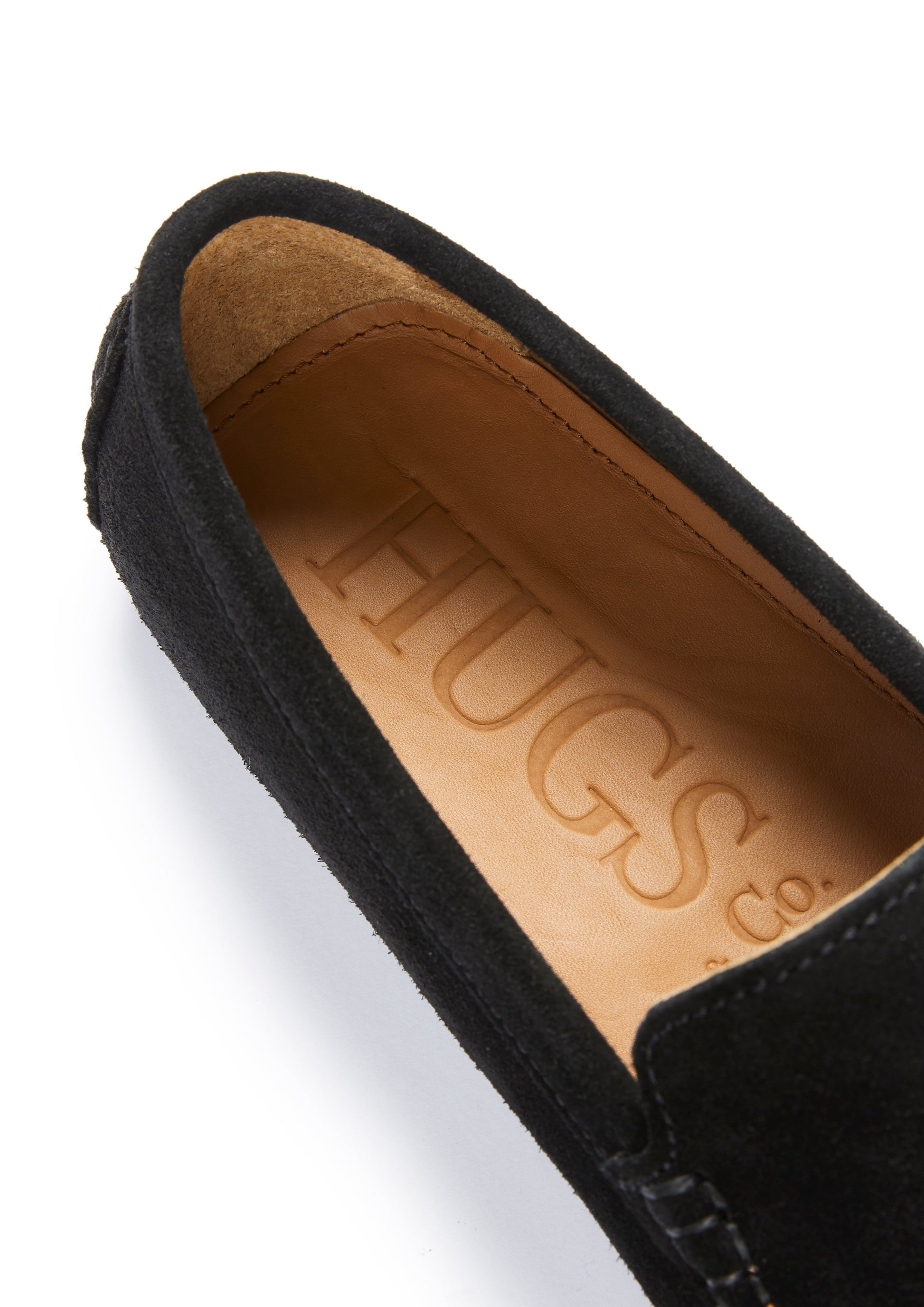 Black loafer with tan interior on a white background