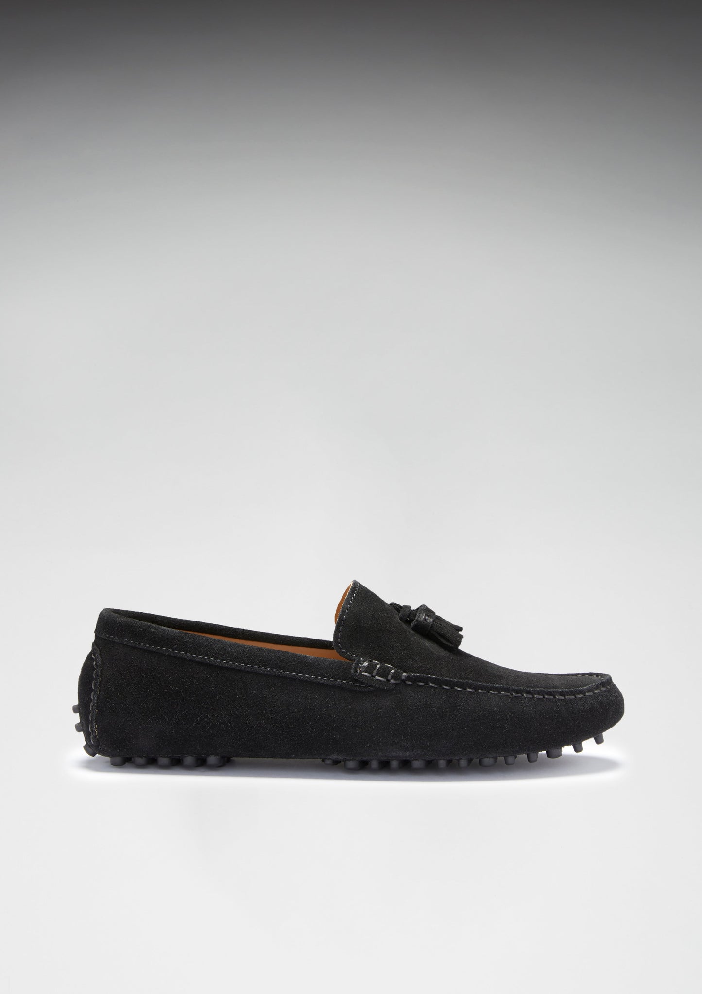 Black suede loafer shoe on a light gray background