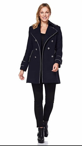 Woman wearing a navy coat with white trim on a white background