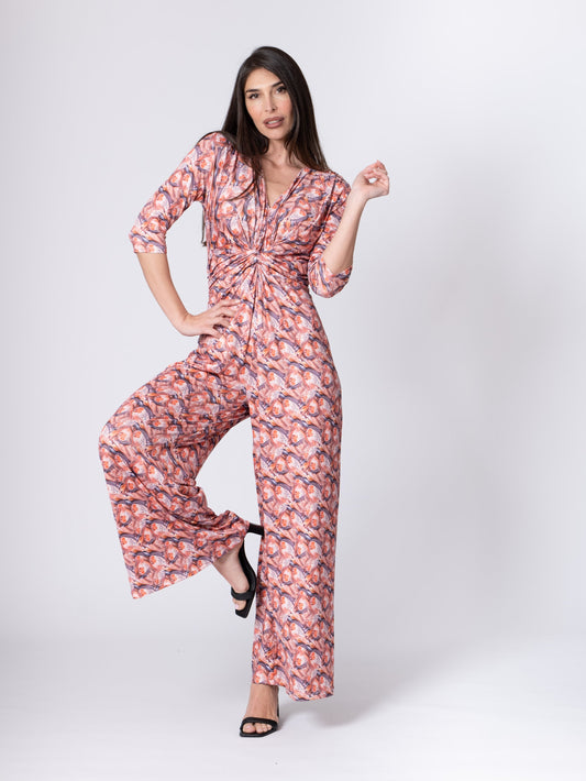 Woman wearing a pink floral jumpsuit on a white background