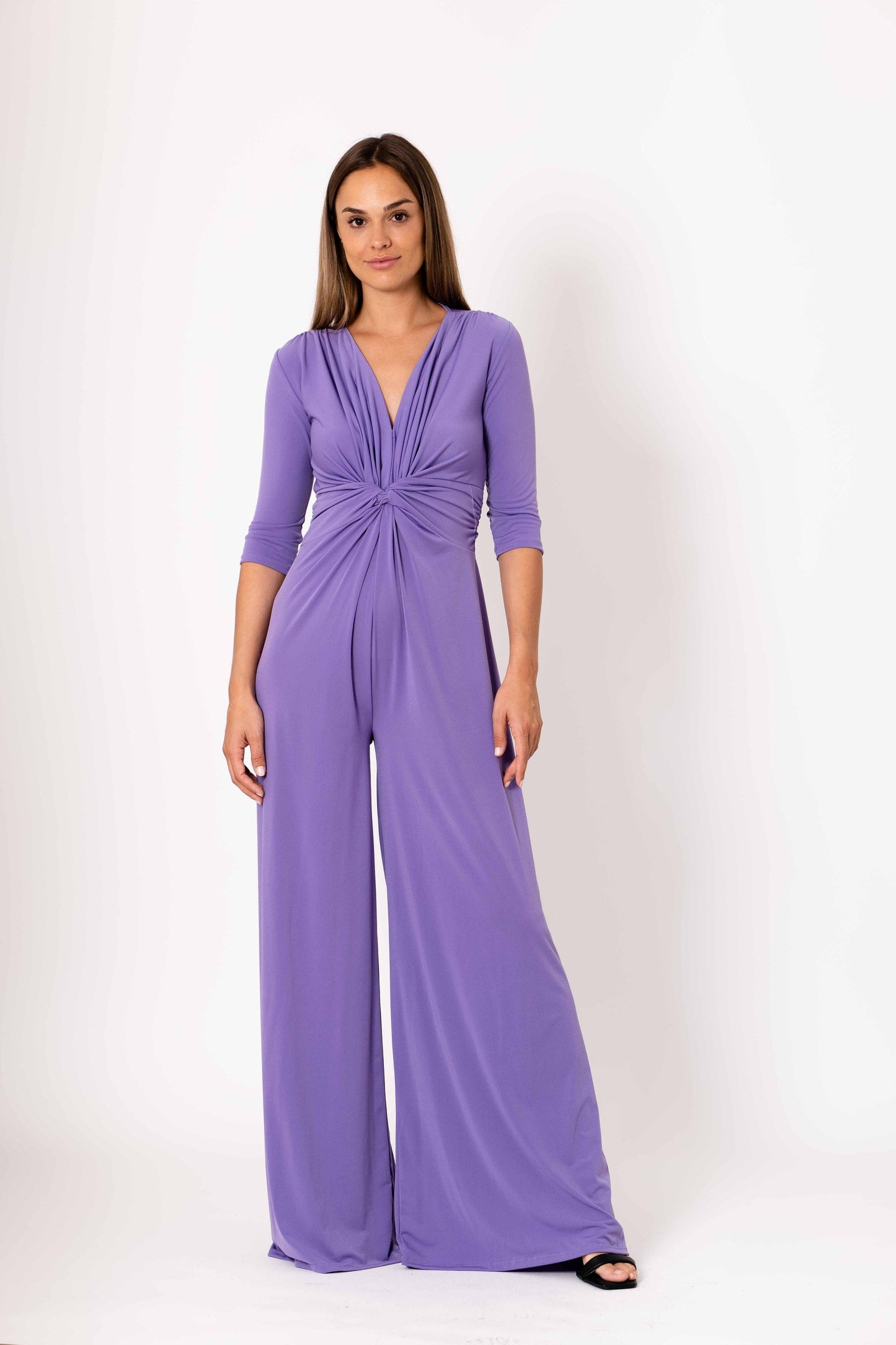 Woman wearing a purple jumpsuit on a white background