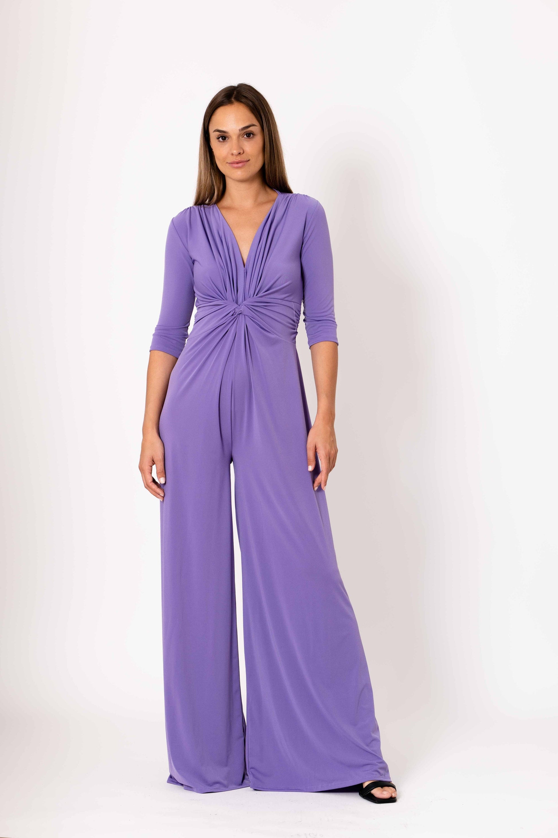 Woman wearing a purple jumpsuit on a white background