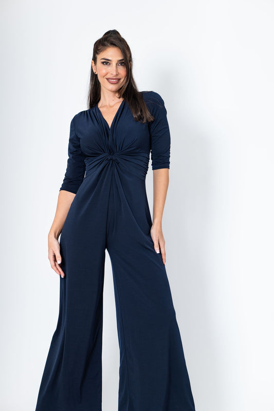 Woman wearing a navy blue jumpsuit on a white background