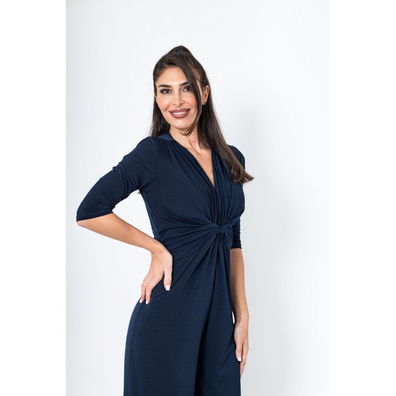 Woman wearing a navy blue jumpsuit on a white background