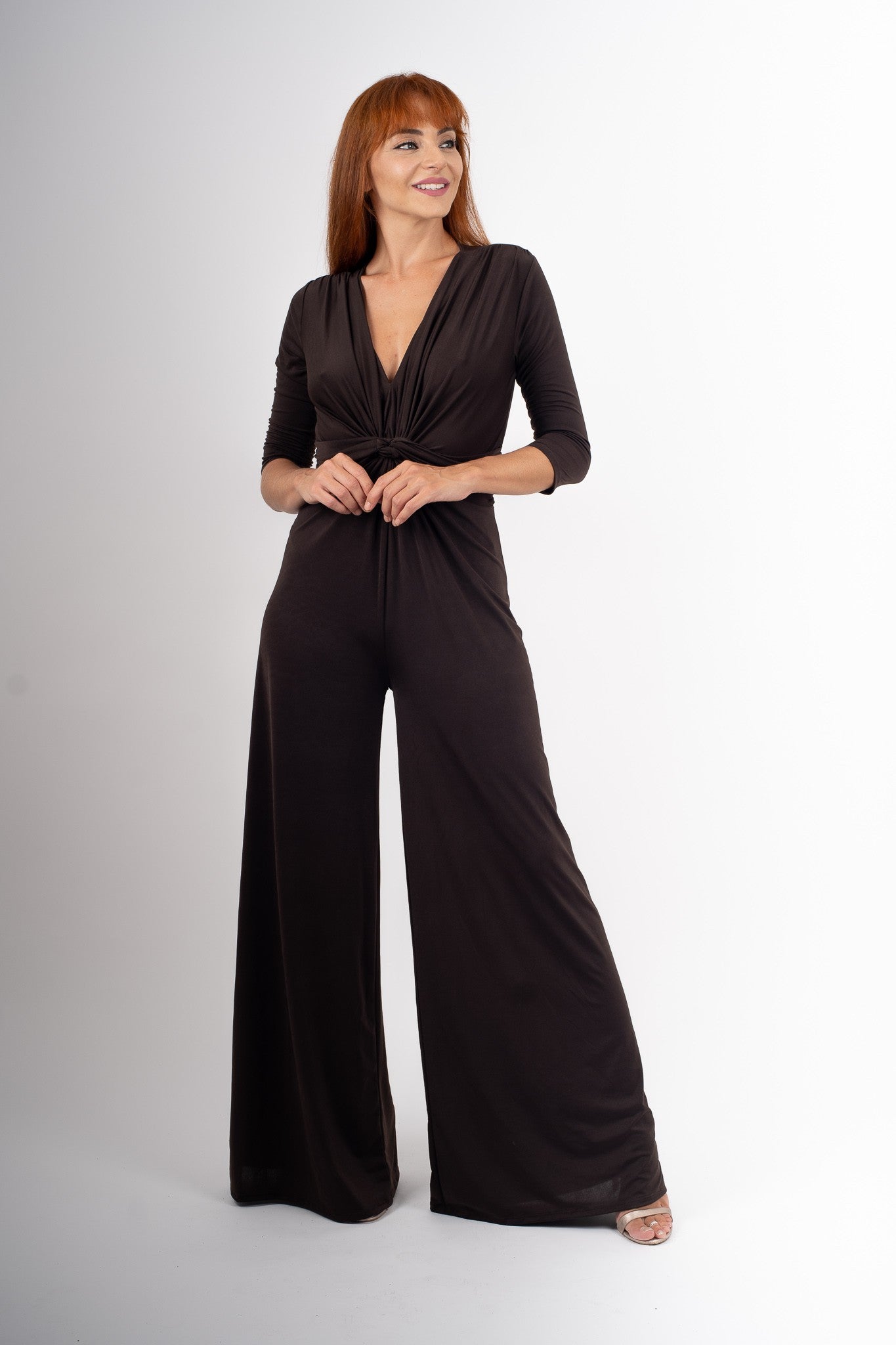 Woman wearing a brown jumpsuit on a white background