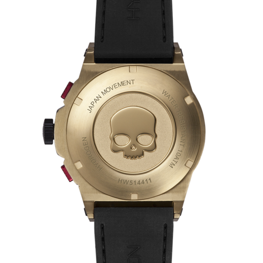 Gold watch case with skull design and black strap on a white background