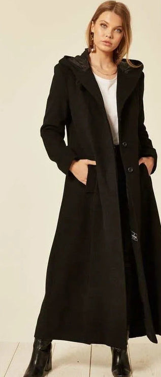 Woman wearing a black coat with a plain background
