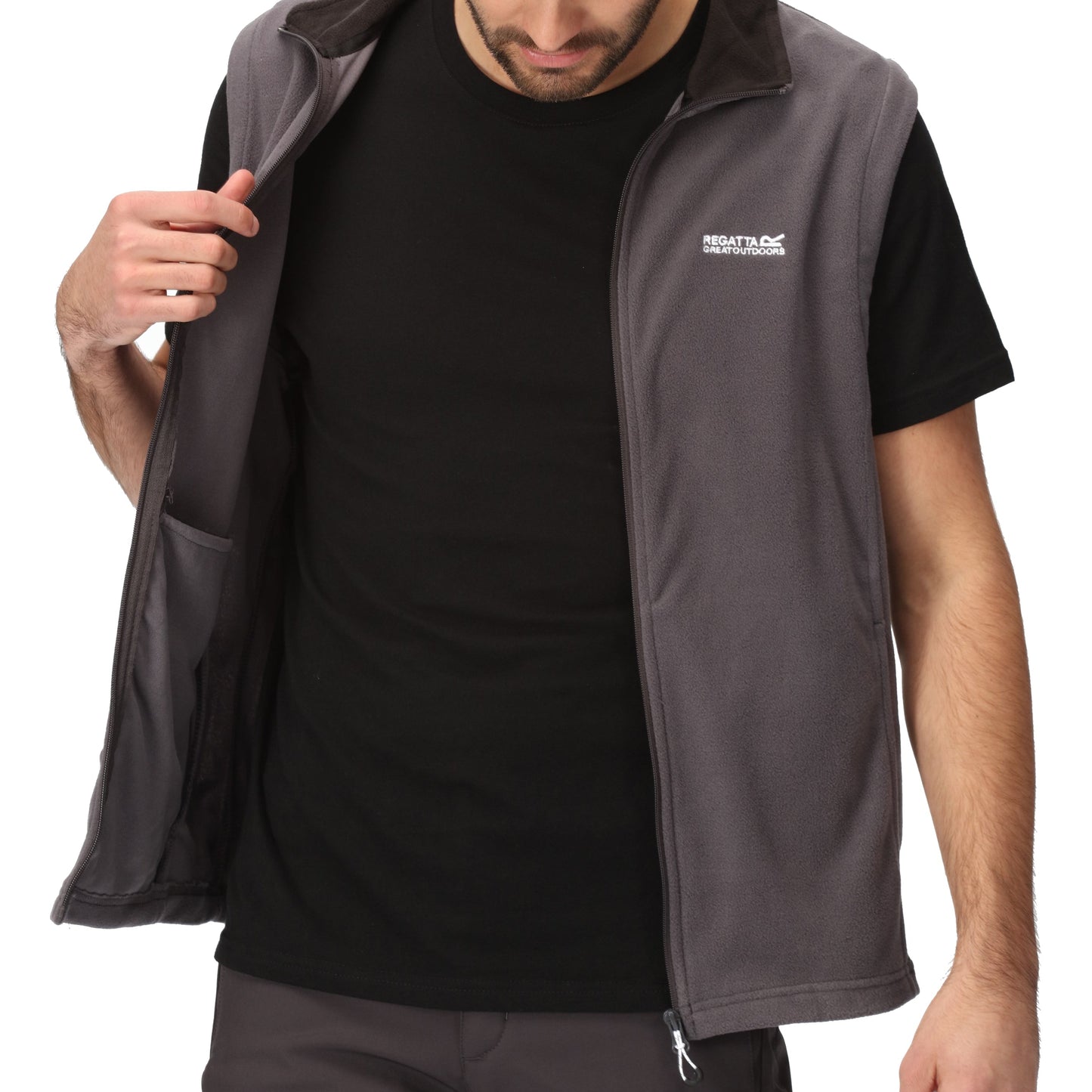 Man wearing a gray vest over a black shirt with a visible brand logo on a white background