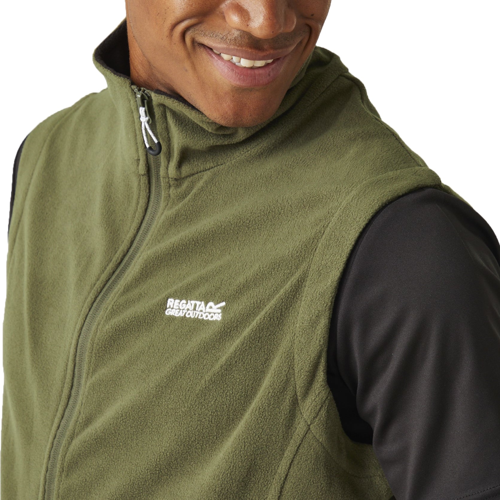 Person wearing a green vest with a brand logo on a white background