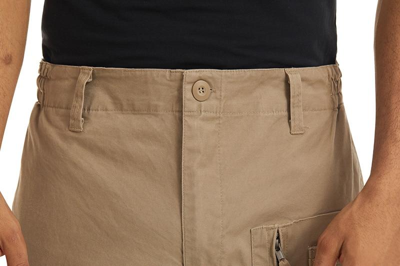 Close-up of beige pants with a button on a white background