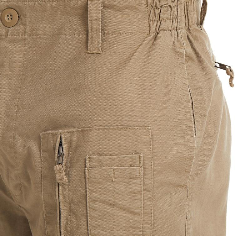 Close-up of beige pants with a pocket and button on a white background