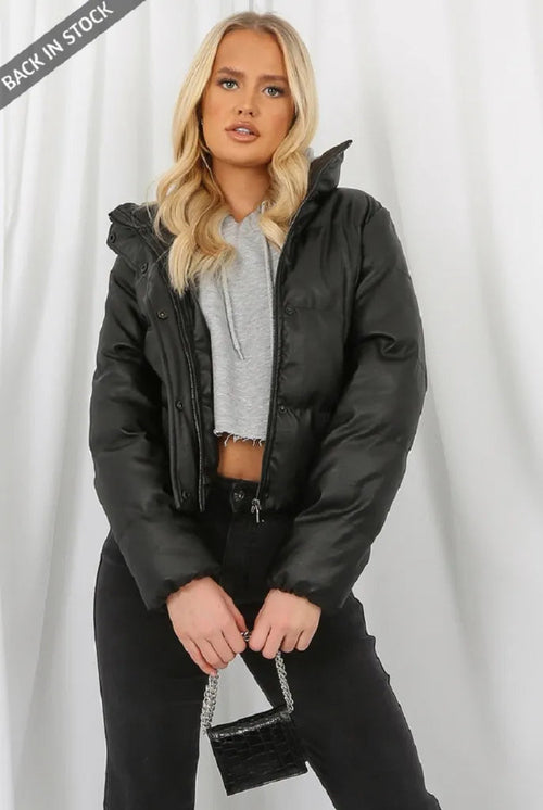 Woman wearing a black puffer jacket with a gray background