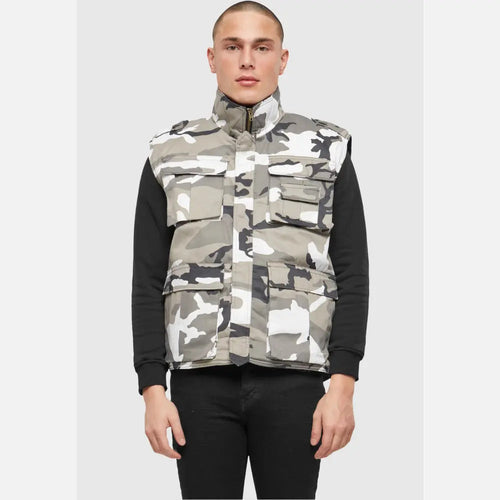 Person wearing a camouflage vest over a black shirt on a white background