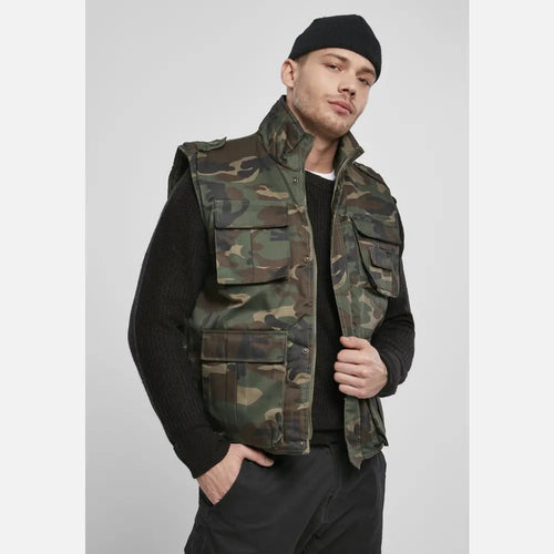 Person wearing a camouflage vest on a plain background