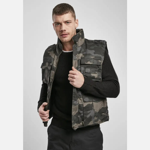 Man wearing a camouflage vest on a plain background