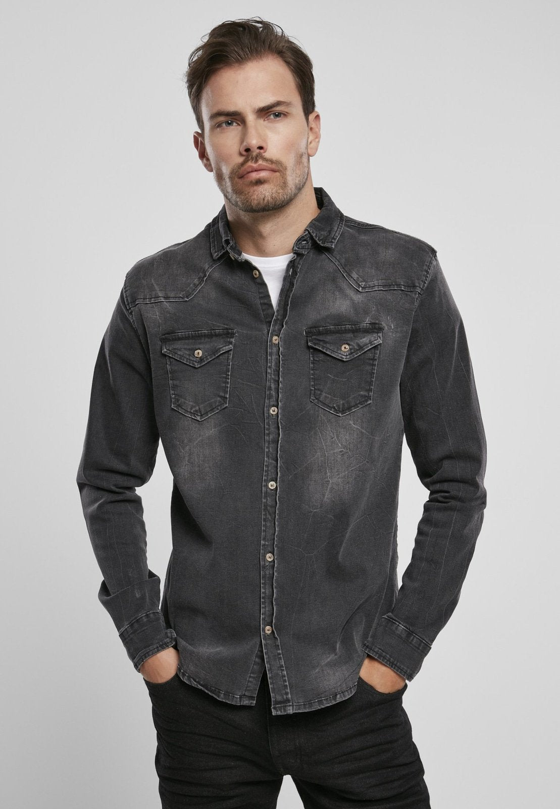 Man wearing a black denim shirt against a gray background