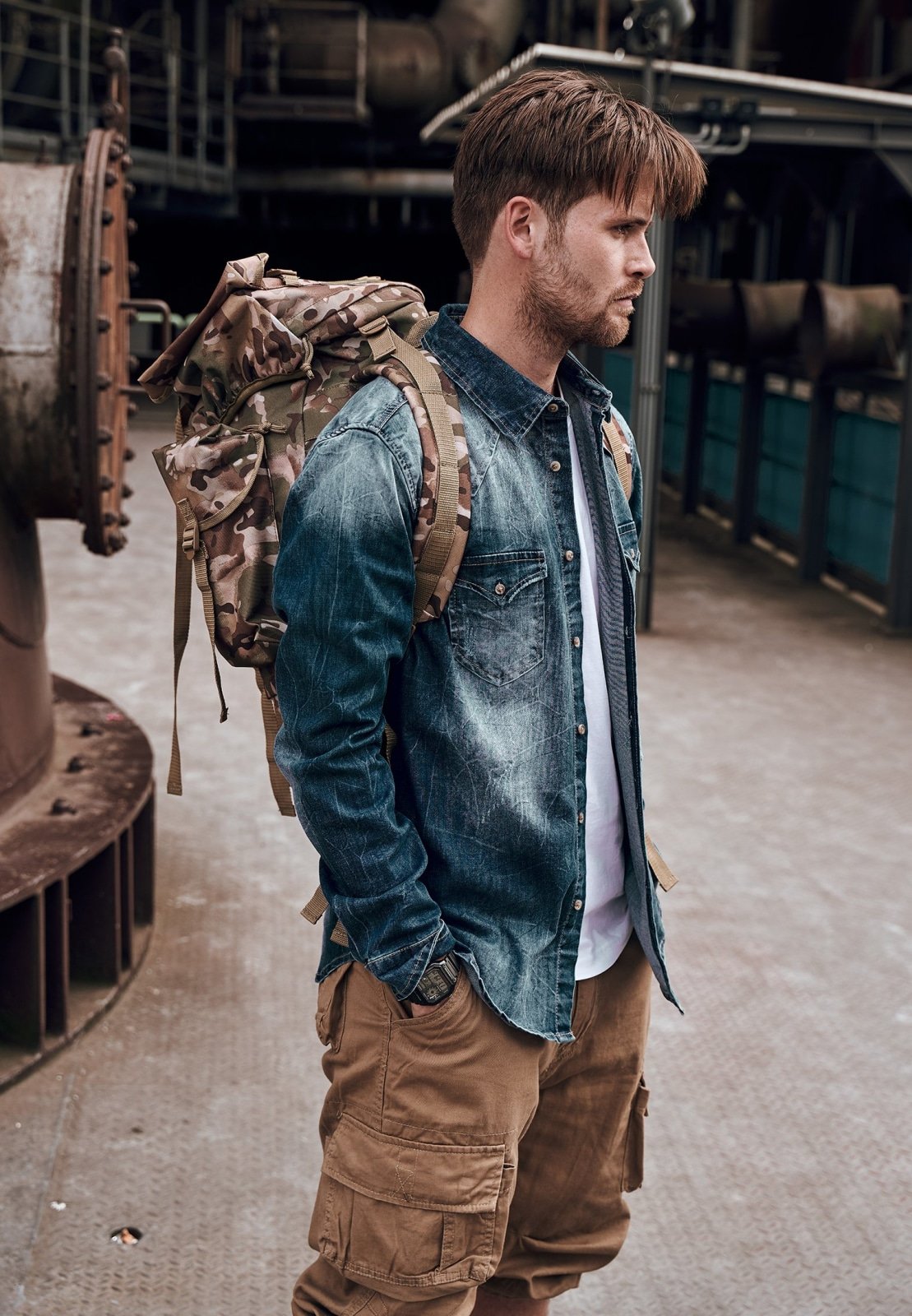 Man wearing a large backpack in an industrial setting