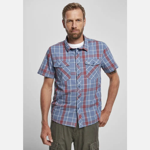 Man wearing a blue and red plaid shirt on a light gray background