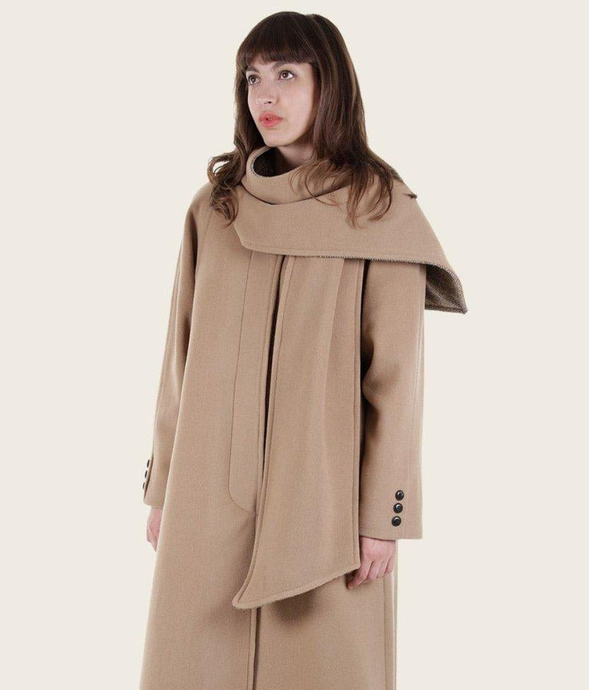 Woman wearing a beige coat with a large collar on a white background