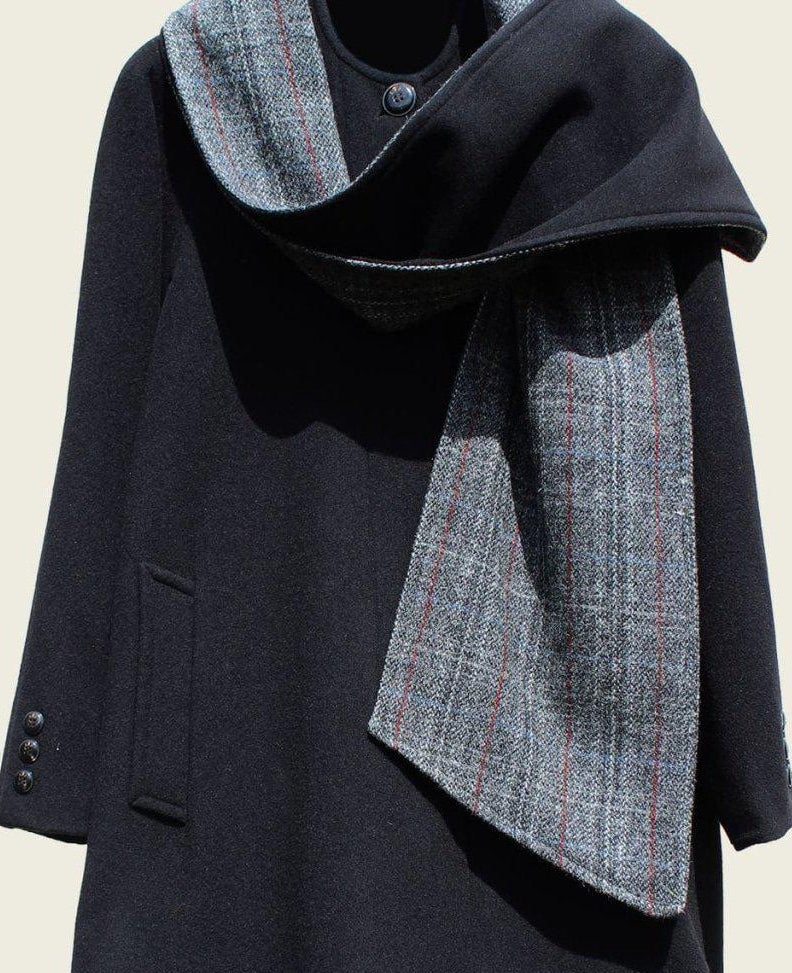 Dark coat with a plaid scarf on a beige background