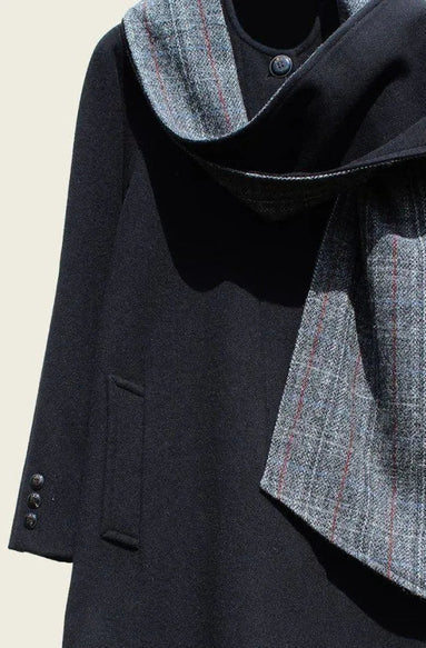 Dark coat with a plaid scarf on a beige background