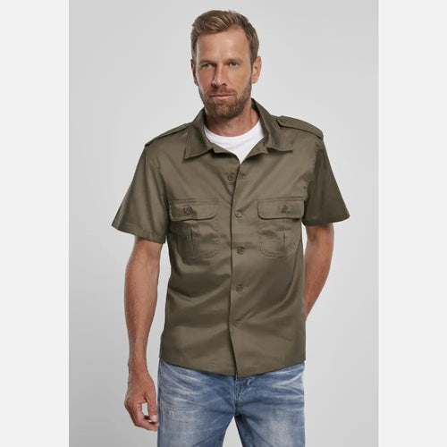 Man wearing a green short-sleeve shirt with pockets on a light gray background