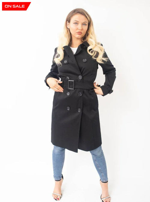 Woman wearing a black trench coat on a white background