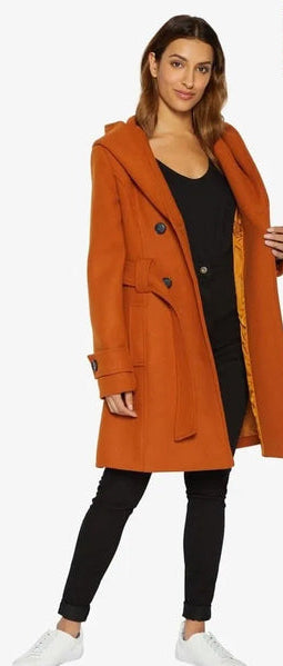 Woman wearing an orange coat with a white background.