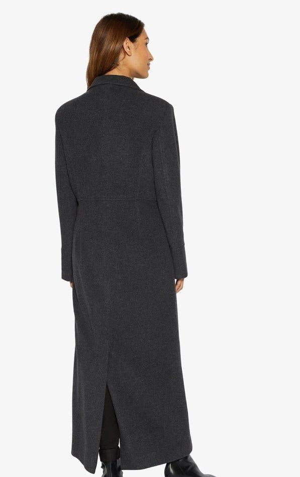 Woman wearing a long dark gray coat on a white background