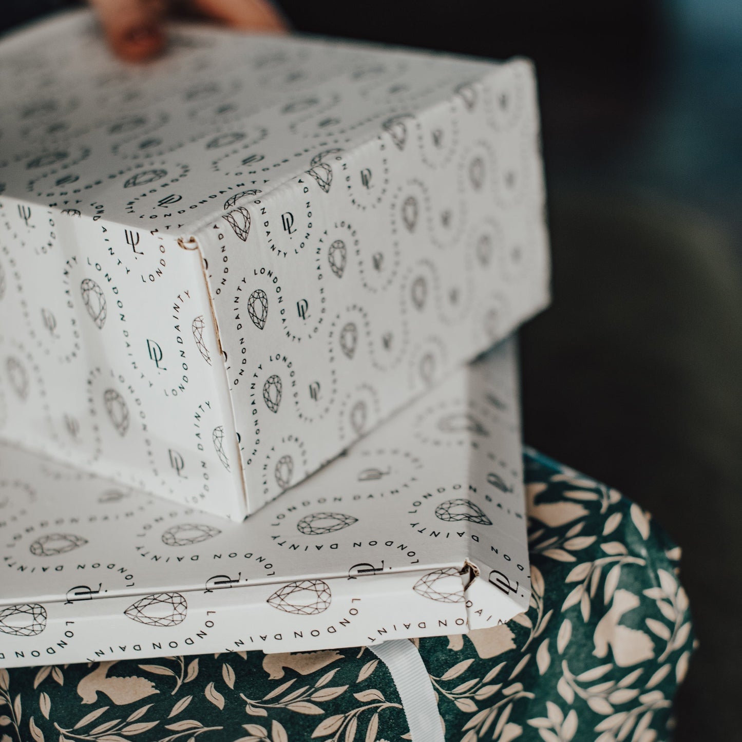 Stack of patterned boxes on a green fabric surface