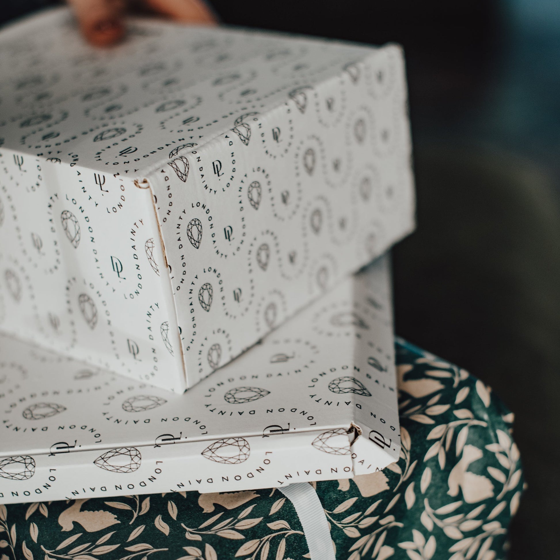 Stack of patterned boxes on a green fabric surface